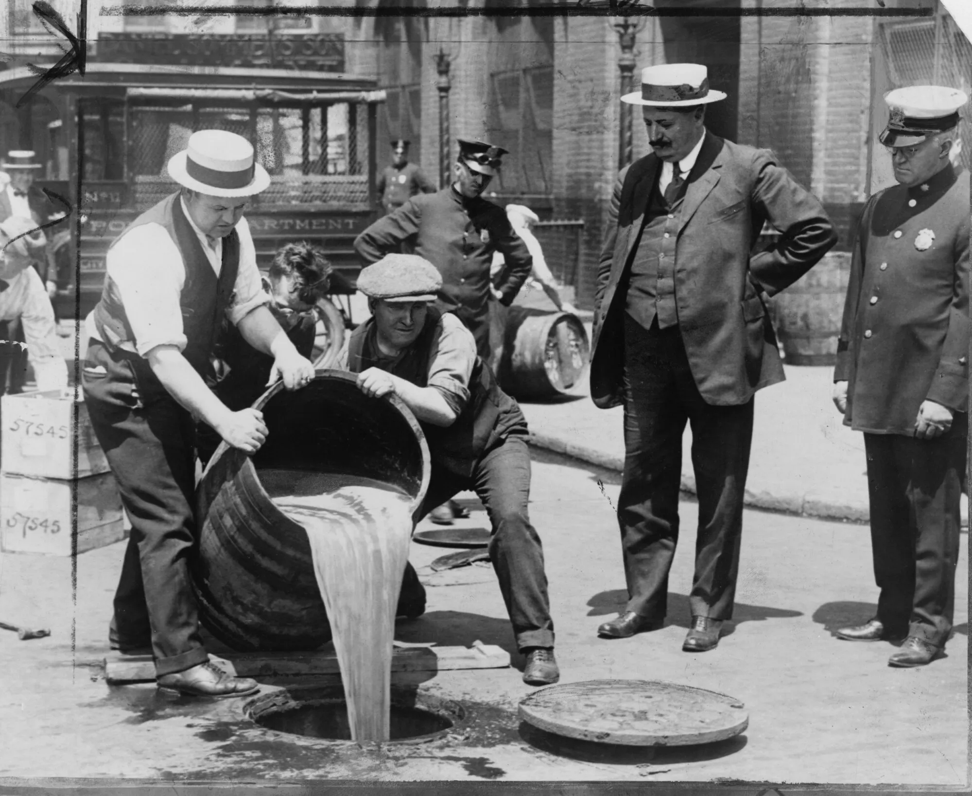 Agents pour confiscated liquor into a sewer during a raid at the height of Prohibition, New York, 1921; on the right, Deputy Police Commissioner John A. Leach. Photo: Library of Congress. Licence: public domain (image cropped to the edge of the print and resized). Source: Wikimedia Commons